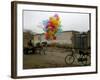 Horse Drawn Cart Drives Past as Balloons Tied to a Bicycle Flutter in the Wind-null-Framed Photographic Print