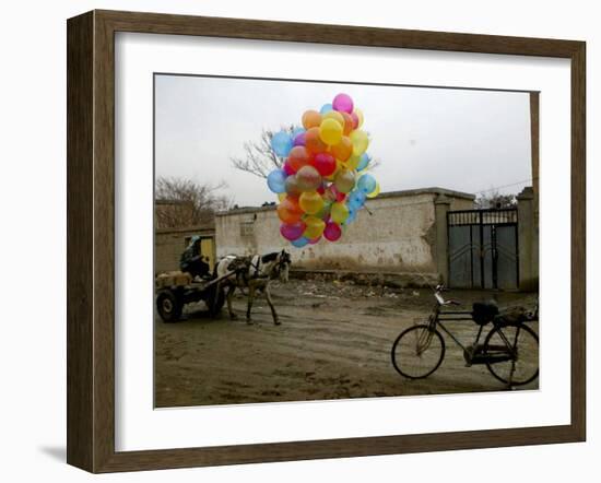 Horse Drawn Cart Drives Past as Balloons Tied to a Bicycle Flutter in the Wind-null-Framed Photographic Print