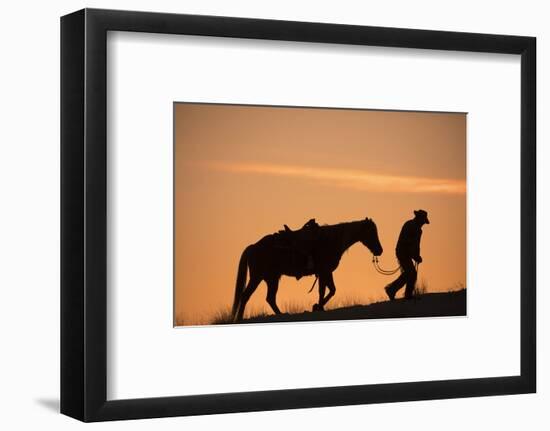Horse drive in winter, Shell, Wyoming. Cowboy leading his horse at sunset and silhouetted.-Darrell Gulin-Framed Photographic Print