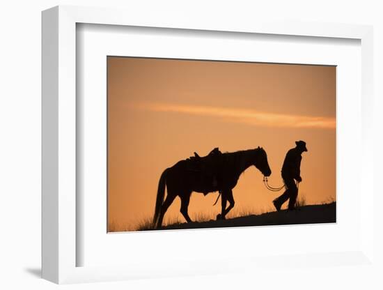 Horse drive in winter, Shell, Wyoming. Cowboy leading his horse at sunset and silhouetted.-Darrell Gulin-Framed Photographic Print