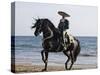 Horseman in Traditional Dress Riding Black Andalusian Stallion on Beach, Ojai, California, USA-Carol Walker-Stretched Canvas