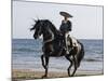 Horseman in Traditional Dress Riding Black Andalusian Stallion on Beach, Ojai, California, USA-Carol Walker-Mounted Photographic Print