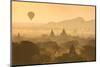 Hot air balloons fly over the temples of Bagan at sunrise on a misty morning, Myanmar-Tim Mannakee-Mounted Photographic Print