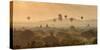 Hot air balloons fly over the temples of Bagan at sunrise on a misty morning, Myanmar-Tim Mannakee-Stretched Canvas