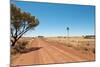 Hot Dusty Road across Flat Landscape with Water Vane-Will Wilkinson-Mounted Photographic Print