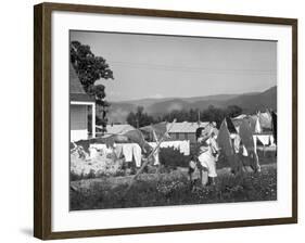 Housewife in Tygart Valley Removing Laundry from Clothesline, Her Young Daughter Stands Beside Her-Carl Mydans-Framed Photographic Print