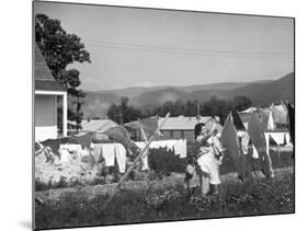 Housewife in Tygart Valley Removing Laundry from Clothesline, Her Young Daughter Stands Beside Her-Carl Mydans-Mounted Photographic Print