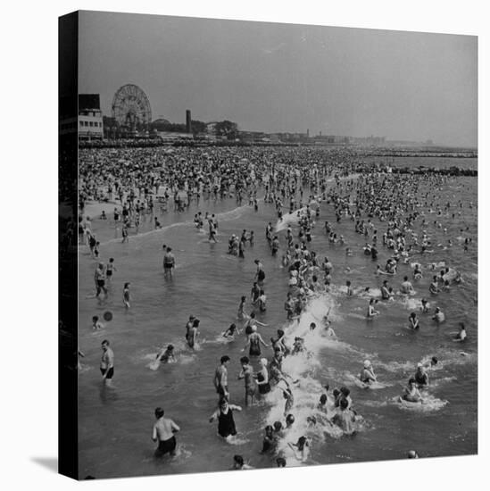 Huge Crowd Gathered in the Surf and at the Beach in Front of Coney Island Amusement Park-Marie Hansen-Stretched Canvas