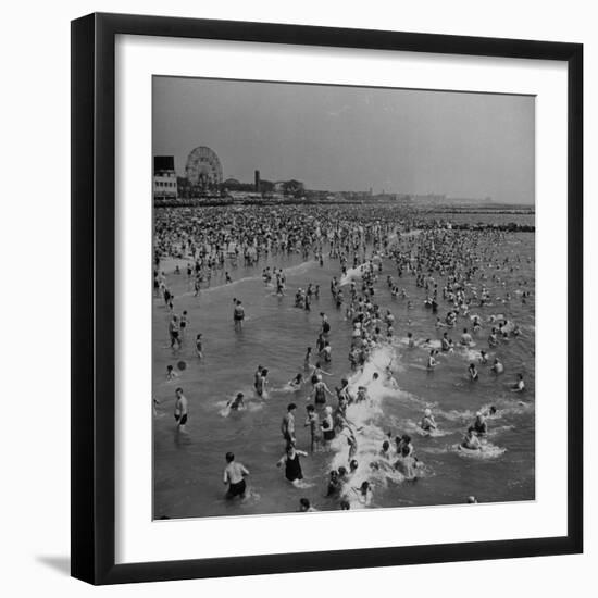 Huge Crowd Gathered in the Surf and at the Beach in Front of Coney Island Amusement Park-Marie Hansen-Framed Premium Photographic Print