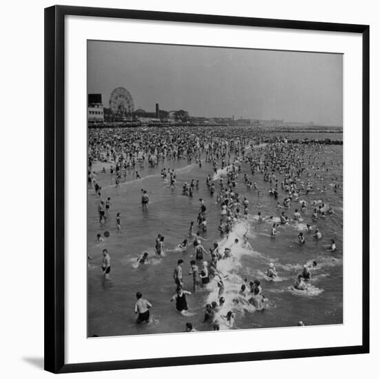 Huge Crowd Gathered in the Surf and at the Beach in Front of Coney Island Amusement Park-Marie Hansen-Framed Photographic Print