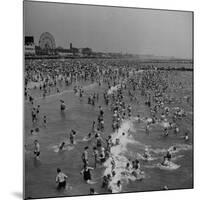 Huge Crowd Gathered in the Surf and at the Beach in Front of Coney Island Amusement Park-Marie Hansen-Mounted Photographic Print