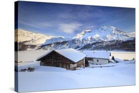 Huts and mountains covered in snow at sunset Spluga Maloja Canton of Graubunden Engadin Switzerland-ClickAlps-Stretched Canvas