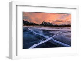 Ice cracks along Abraham Lake in Banff, Canada at sunset with pink clouds and scenic mountains-David Chang-Framed Photographic Print