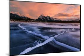Ice cracks along Abraham Lake in Banff, Canada at sunset with pink clouds and scenic mountains-David Chang-Mounted Photographic Print