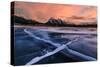 Ice cracks along Abraham Lake in Banff, Canada at sunset with pink clouds and scenic mountains-David Chang-Stretched Canvas