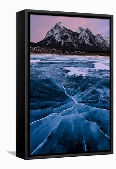 Ice cracks along Abraham Lake in Banff, Canada with purple clouds and scenic mountains-David Chang-Framed Stretched Canvas