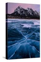 Ice cracks along Abraham Lake in Banff, Canada with purple clouds and scenic mountains-David Chang-Stretched Canvas