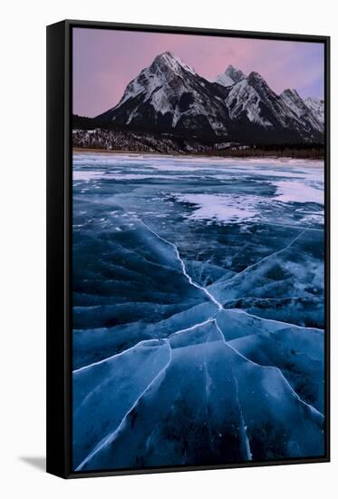 Ice cracks along Abraham Lake in Banff, Canada with purple clouds and scenic mountains-David Chang-Framed Stretched Canvas