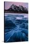 Ice cracks along Abraham Lake in Banff, Canada with purple clouds and scenic mountains-David Chang-Stretched Canvas