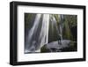 Iceland, Seljalandsfoss. Woman on large rock in front of streaming falls in green slot canyon. (MR)-Mark Williford-Framed Photographic Print