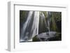 Iceland, Seljalandsfoss. Woman on large rock in front of streaming falls in green slot canyon. (MR)-Mark Williford-Framed Photographic Print