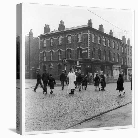 In Liverpool, a Lollipop Lady Helps Children Cross a Cobbled Street-Henry Grant-Stretched Canvas