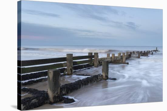 Incoming waves hitting a groyne at Walcott, Norfolk, England, United Kingdom, Europe-Jon Gibbs-Stretched Canvas
