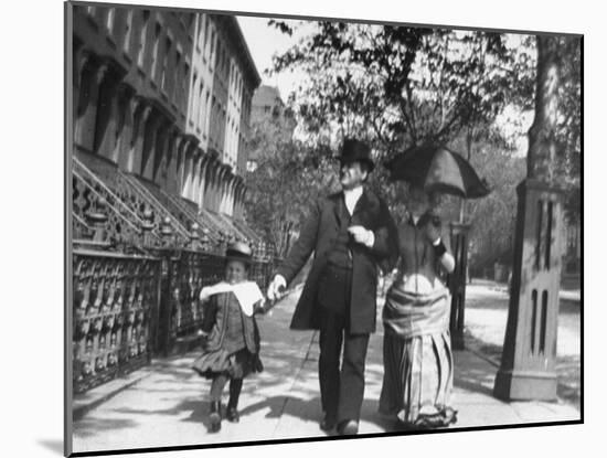 Incredibly Well Dressed Man, Woman and Child Walking by Perfect Brownstone Apartment Buildings-George B^ Brainerd-Mounted Photographic Print