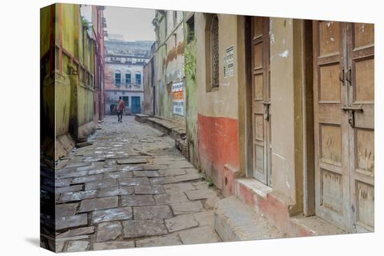 India, Varanasi a Man Walking Down a Stone Tiled Street in the Downtown Area-Ellen Clark-Stretched Canvas
