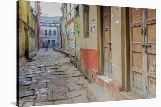 India, Varanasi a Man Walking Down a Stone Tiled Street in the Downtown Area-Ellen Clark-Stretched Canvas