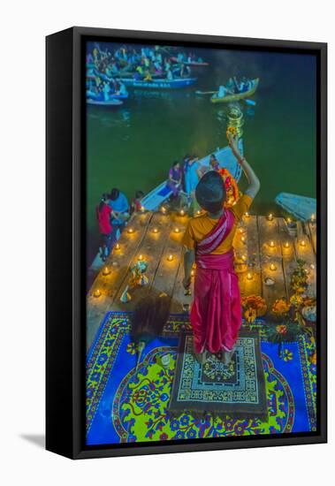 India, Varanasi Young Boy in Pink and Yellow Robes Holds Up an Offering to the Ganges River-Ellen Clark-Framed Stretched Canvas