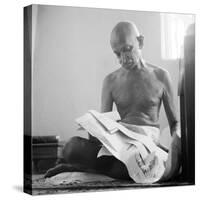 Indian Leader Mohandas Gandhi Reading as He Sits Cross Legged on Floor, at Home-Margaret Bourke-White-Stretched Canvas