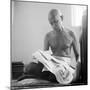 Indian Leader Mohandas Gandhi Reading as He Sits Cross Legged on Floor, at Home-Margaret Bourke-White-Mounted Premium Photographic Print