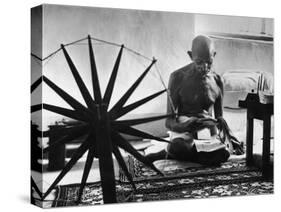 Indian Leader Mohandas Gandhi Reading as He Sits Cross Legged on Floor-Margaret Bourke-White-Stretched Canvas