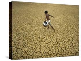 Indian Village Boy Runs Through a Parched Field on World Water Day in Berhampur, India-null-Stretched Canvas