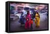 Indian women in colourful saris walk along streets-Charles Bowman-Framed Stretched Canvas