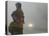 Indian Worker Carries His Daughter in the Morning Fog in the Outskirts of Jammu, India-null-Stretched Canvas