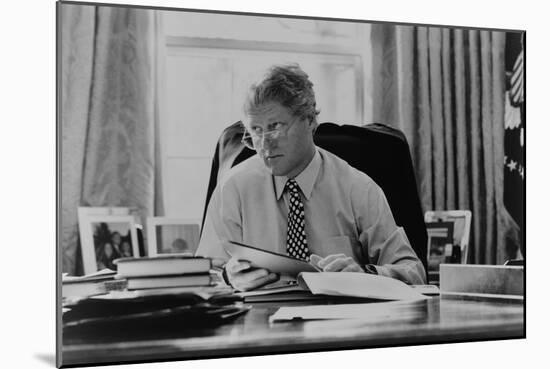 Informal Portrait of President Bill Clinton at His Desk in the Oval Office-null-Mounted Photo