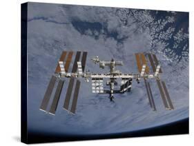 International Space Station Set Against the Background of a Cloud Covered Earth-null-Stretched Canvas