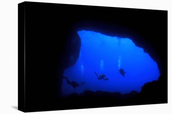 Into Darkness: Underwater Cave Scuba Diving Silhouettes-Rich Carey-Stretched Canvas