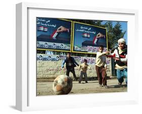 Iraqi Boys Play Soccer Below the Poster Reading "To Grant Iraqi Children Better Iraq"-null-Framed Premium Photographic Print