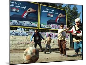 Iraqi Boys Play Soccer Below the Poster Reading "To Grant Iraqi Children Better Iraq"-null-Mounted Premium Photographic Print