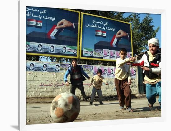 Iraqi Boys Play Soccer Below the Poster Reading "To Grant Iraqi Children Better Iraq"-null-Framed Photographic Print