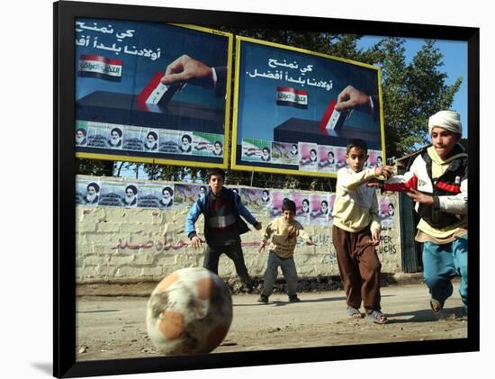 Iraqi Boys Play Soccer Below the Poster Reading "To Grant Iraqi Children Better Iraq"-null-Framed Photographic Print