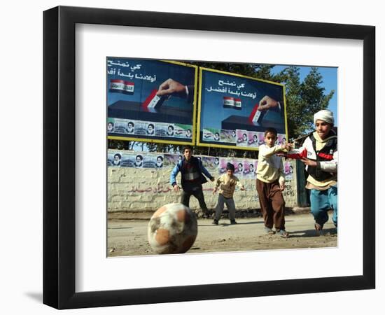 Iraqi Boys Play Soccer Below the Poster Reading "To Grant Iraqi Children Better Iraq"-null-Framed Photographic Print