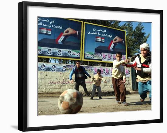Iraqi Boys Play Soccer Below the Poster Reading "To Grant Iraqi Children Better Iraq"-null-Framed Photographic Print
