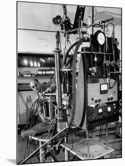 Italian Physicist Enrico Fermi Peering Out from Behind Large, Complicated Machinery in Laboratory-Ralph Morse-Mounted Premium Photographic Print