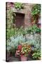 Italy, Tuscany, Pienza. Potted plants in the corner of a street in the town of Pienza.-Julie Eggers-Stretched Canvas