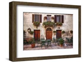 Italy, Tuscany, Pienza. Tables and chairs set up outside for outdoor dining in the town of Pienza.-Julie Eggers-Framed Photographic Print