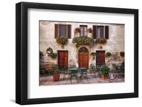 Italy, Tuscany, Pienza. Tables and chairs set up outside for outdoor dining in the town of Pienza.-Julie Eggers-Framed Photographic Print